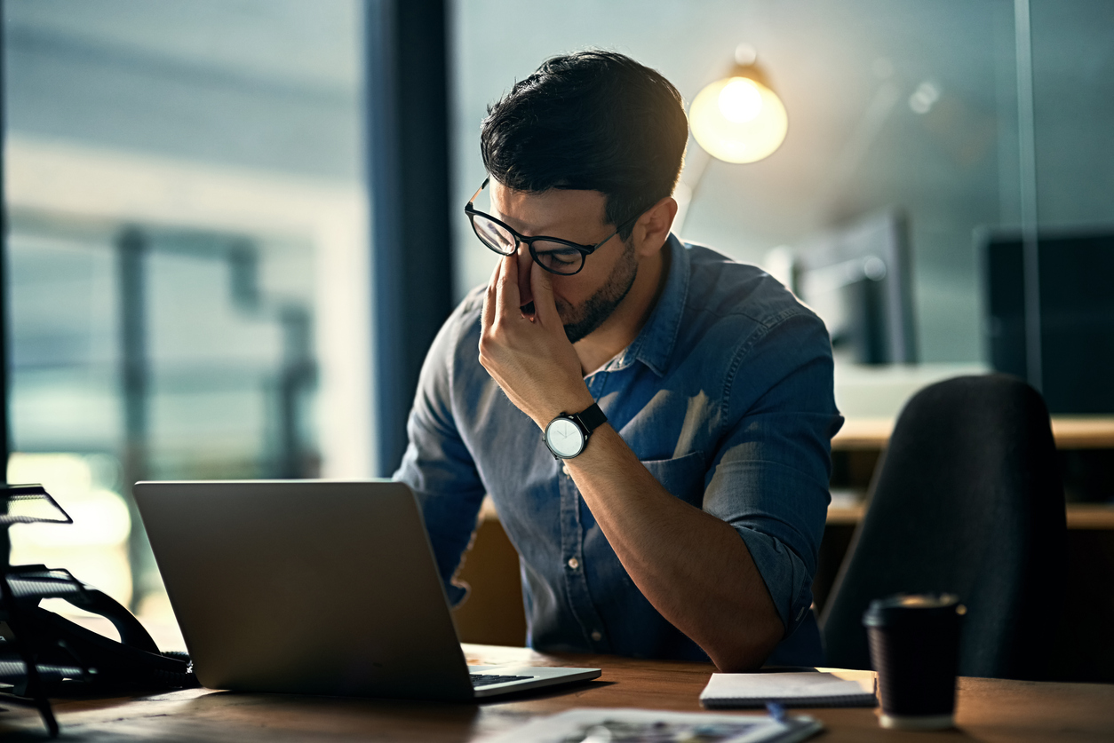 A young businessman experiencing stress during a late night at work